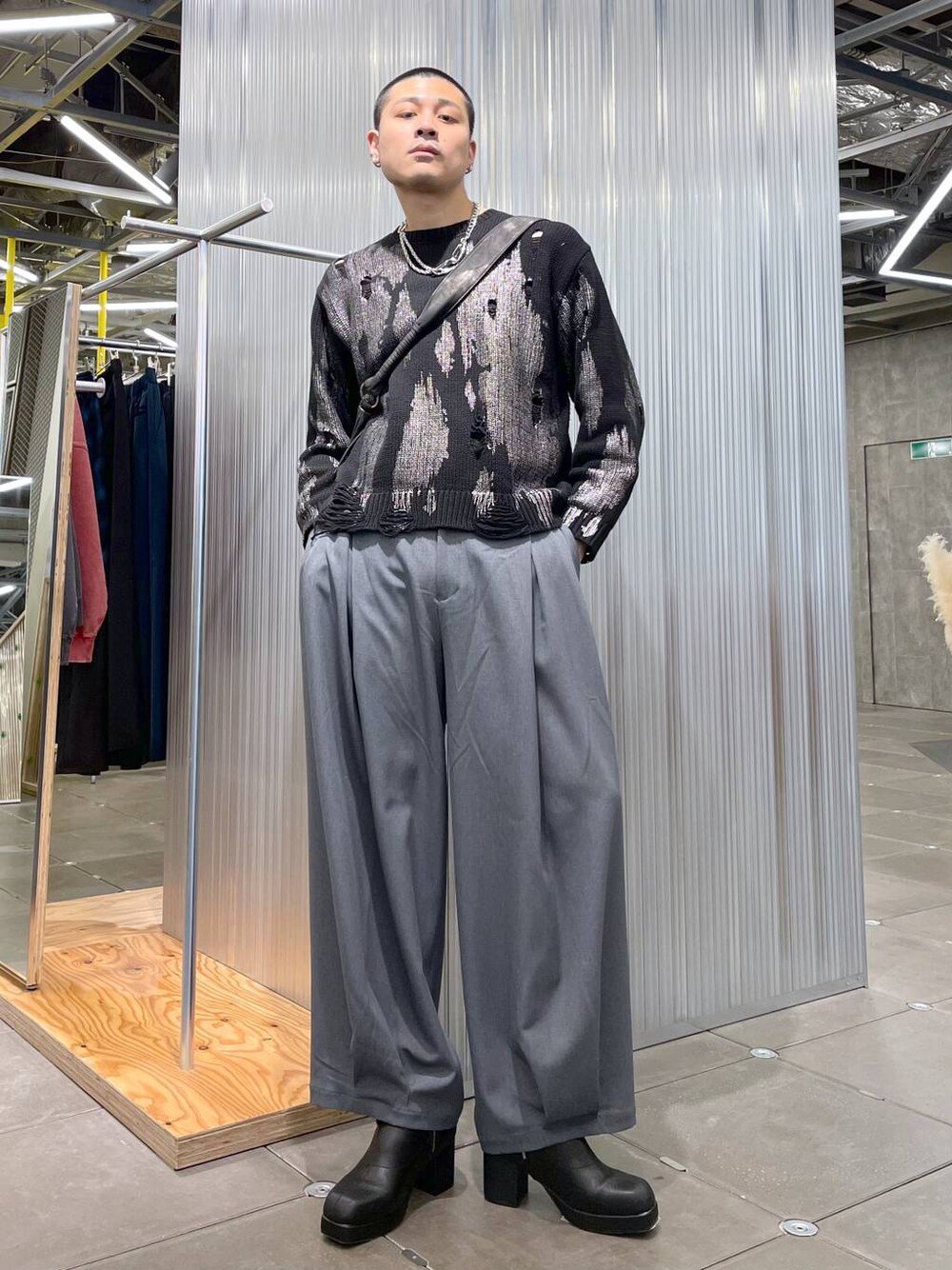 ブラック系のブーツ、ブラック系のニット/セーター、グレー系のショルダーバッグを着用したメンズの冬コーディネートの1枚目の写真