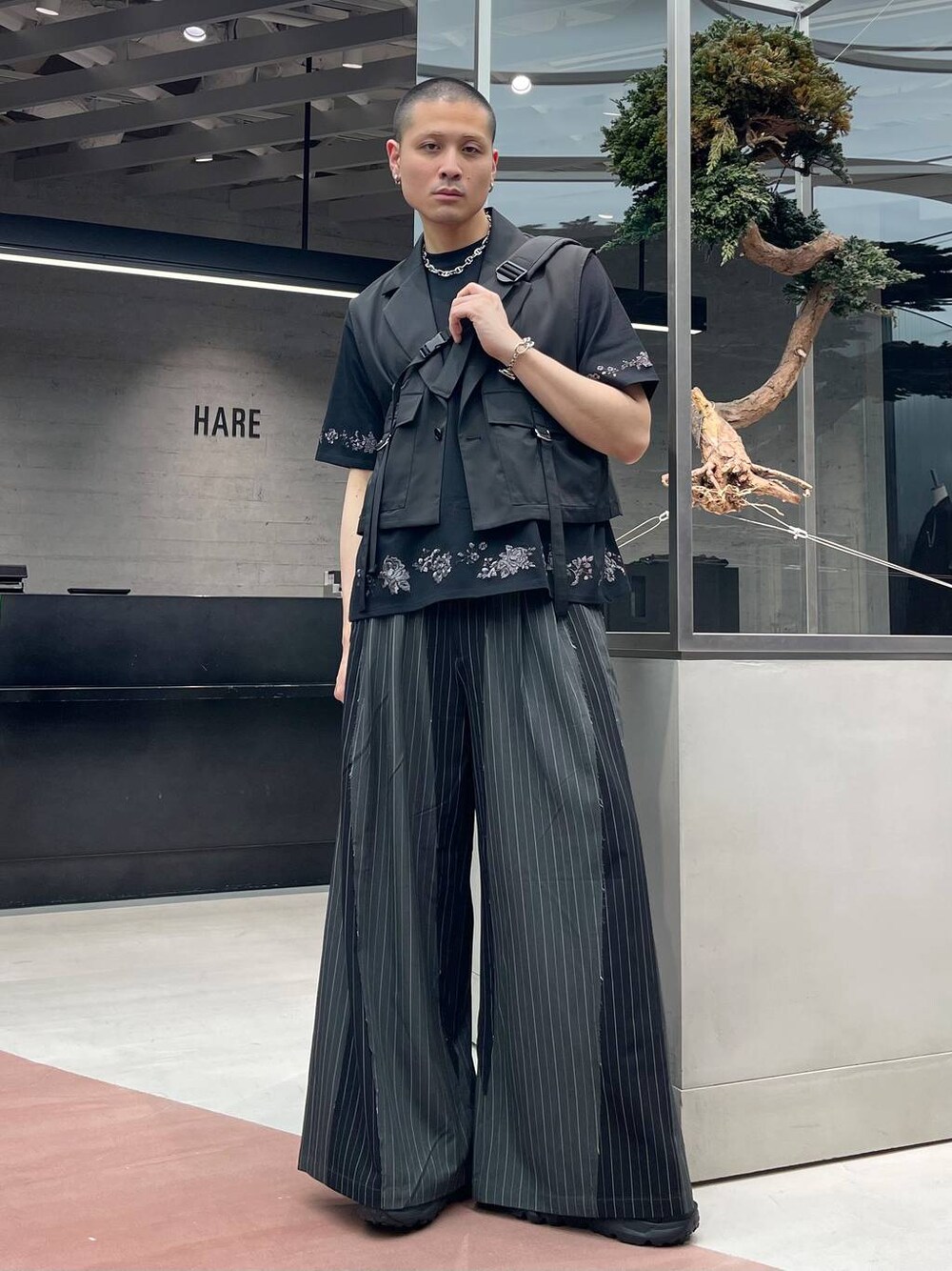 ブラック系のサンダル、ブラック系のベスト、ブラック系のTシャツ/カットソーを着用したメンズの春コーディネートの1枚目の写真