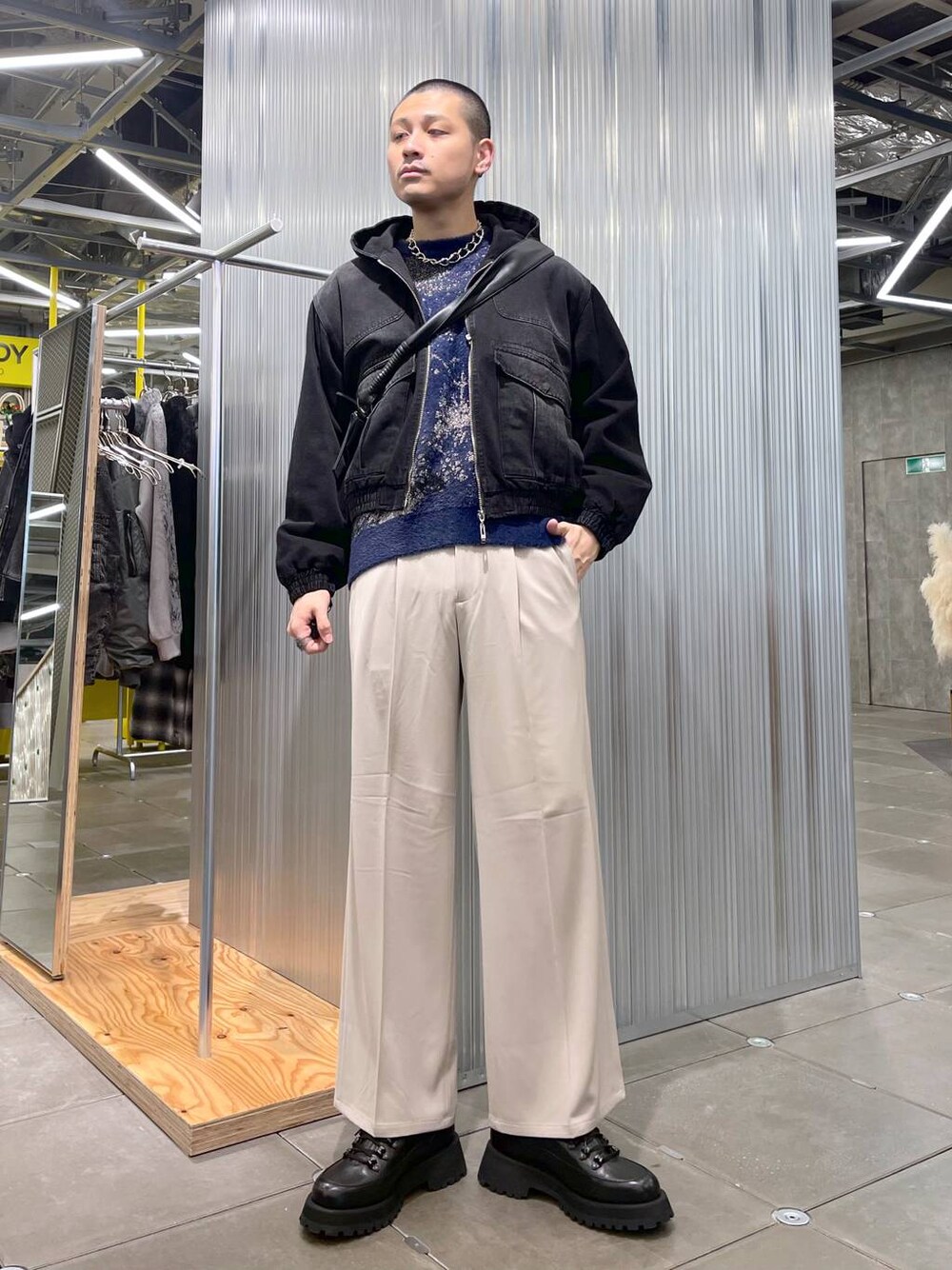 ベージュ系のスラックス、ブルー系のニット/セーター、ブラック系のドレスシューズを着用したメンズの冬コーディネートの1枚目の写真