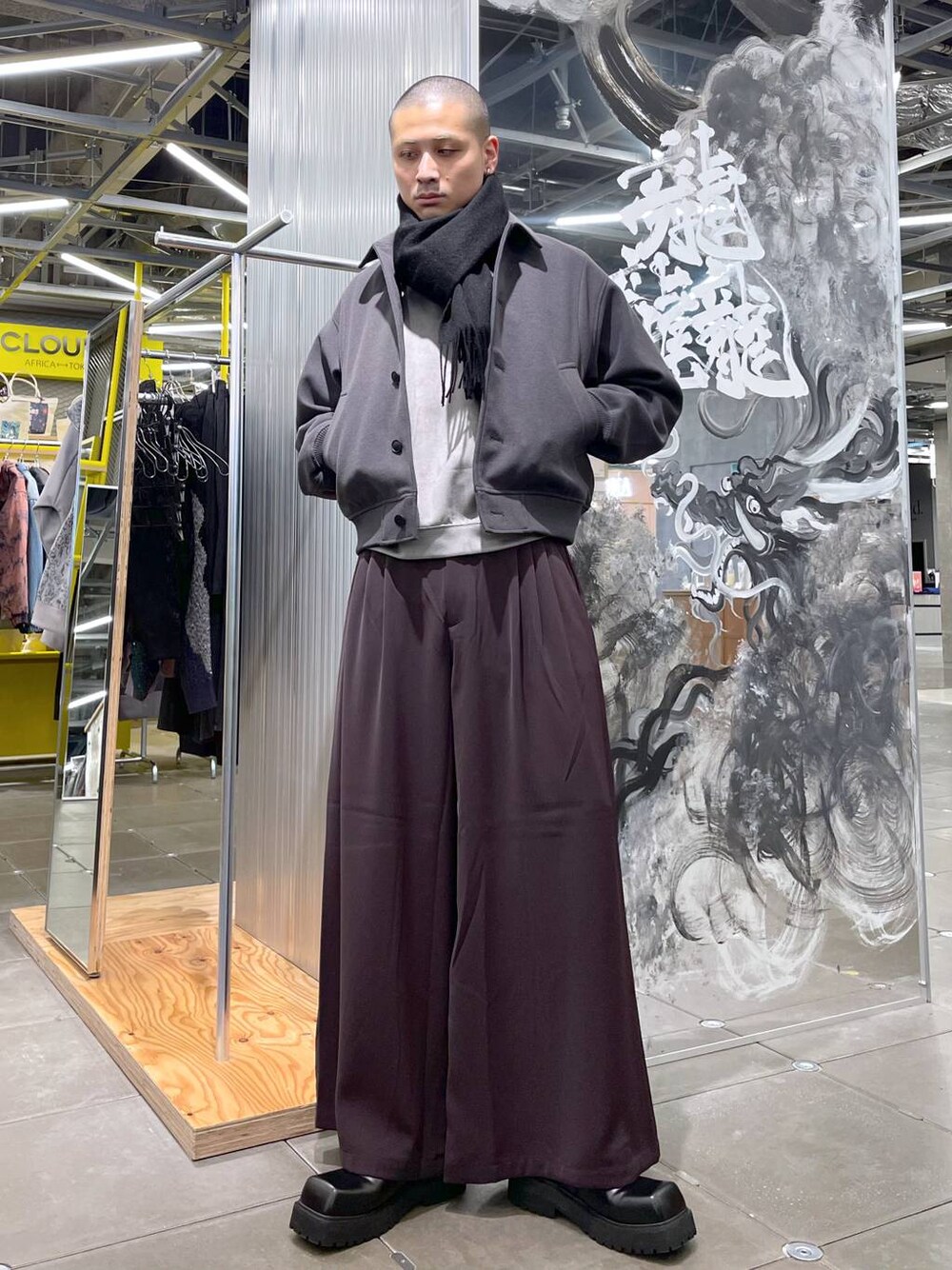 グレー系のブルゾン、レッド系のスラックス、グレー系のスウェットを着用したメンズの冬コーディネートの1枚目の写真