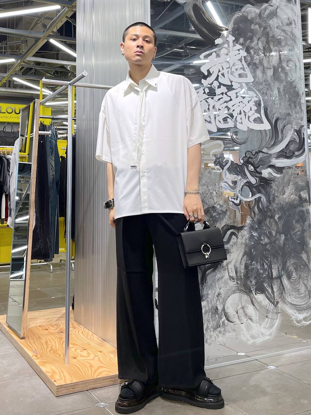 ブラック系のスラックス、ブラック系のショルダーバッグ、ブラック系のサンダルを着用したメンズの夏コーディネートの1枚目の写真