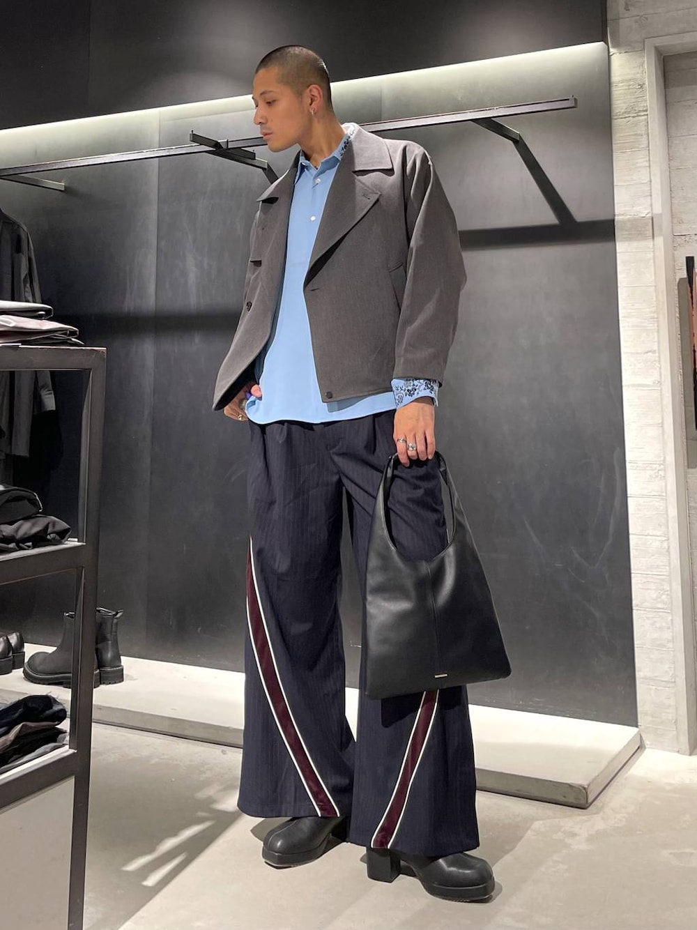 ブラック系のトートバッグ、ブルー系のシャツ/ブラウス、ブラック系のブーツを着用したメンズの秋コーディネートの1枚目の写真