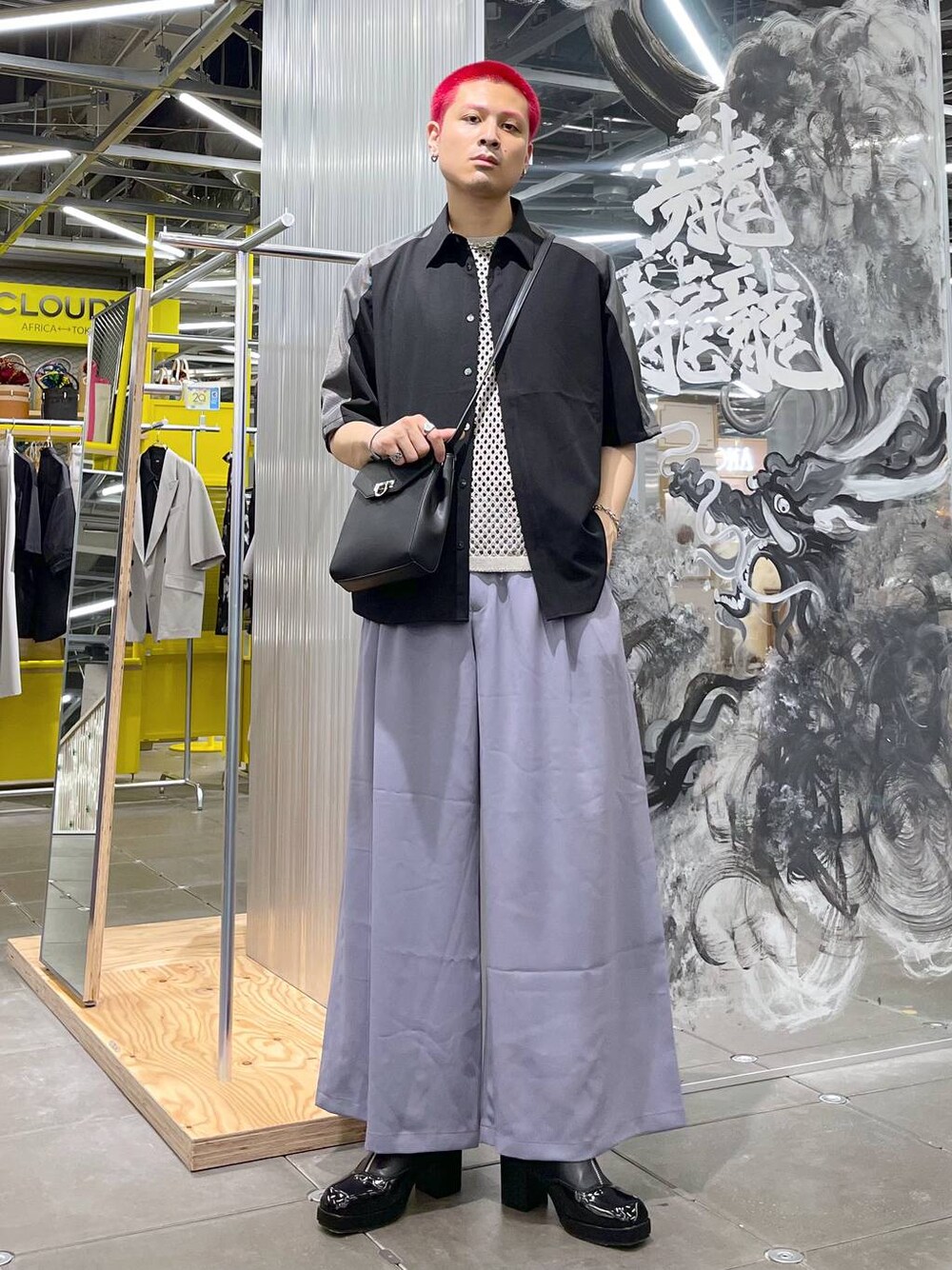 ブラック系のドレスシューズ、ブラック系のショルダーバッグ、パープル系のスラックスを着用したメンズの春コーディネートの1枚目の写真