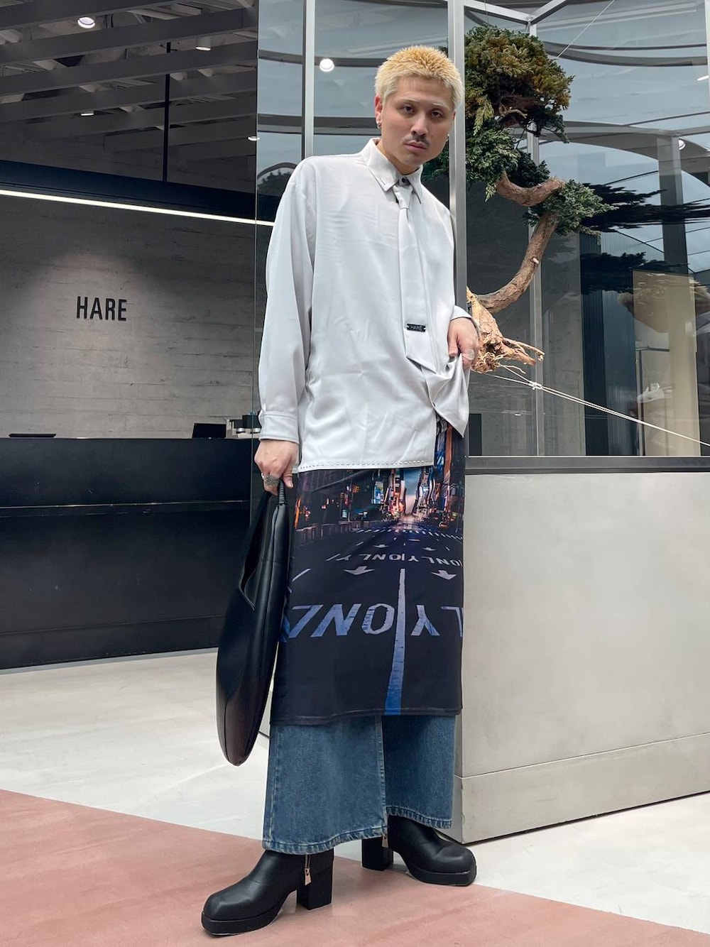 ブルー系のデニムパンツ、ブラック系のブーツ、グレー系のシャツ/ブラウスを着用したメンズの春コーディネートの1枚目の写真