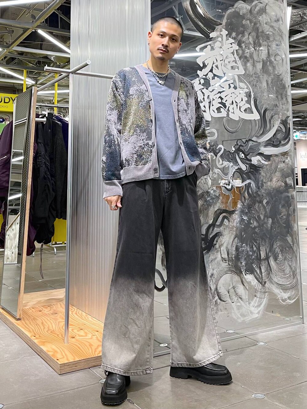 ブラック系のデニムパンツ、グレー系のカーディガン/ボレロ、ブラック系のドレスシューズを着用したメンズの秋コーディネートの1枚目の写真