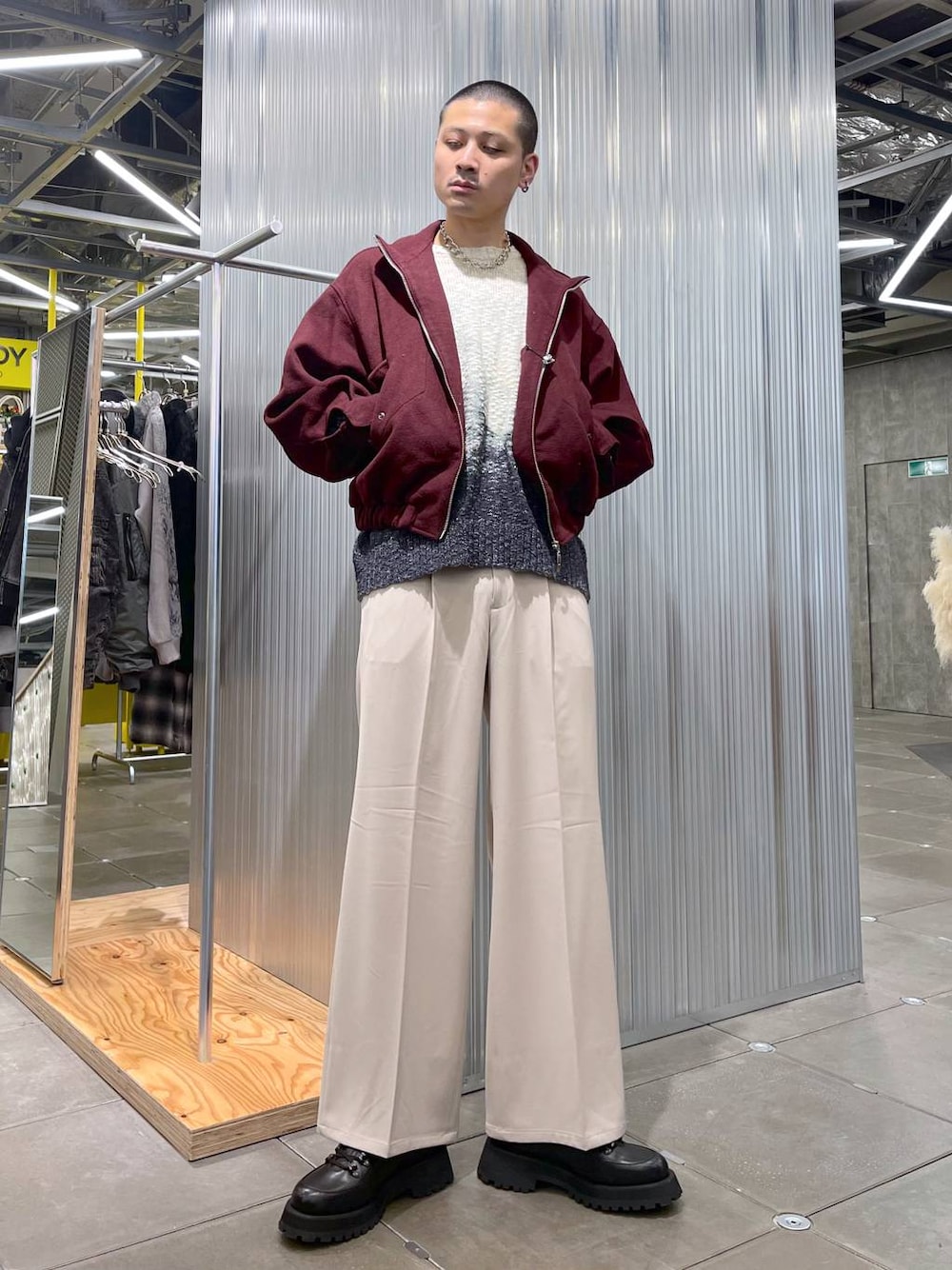 レッド系のブルゾン、ベージュ系のスラックス、ブラック系のドレスシューズを着用したメンズの冬コーディネートの1枚目の写真