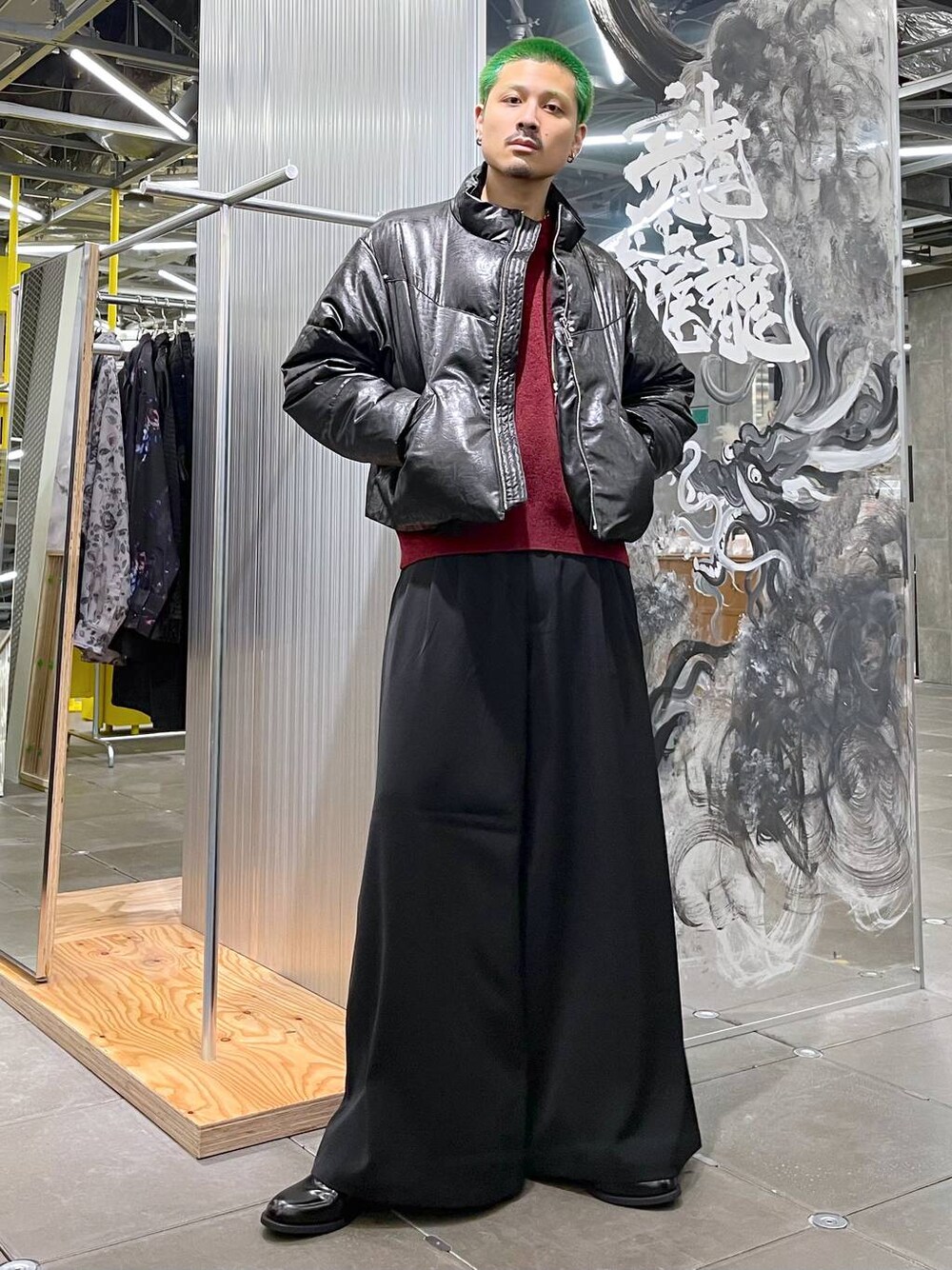 レッド系のニット/セーター、ブラック系のスラックス、ブラック系のドレスシューズを着用したメンズの秋コーディネートの1枚目の写真