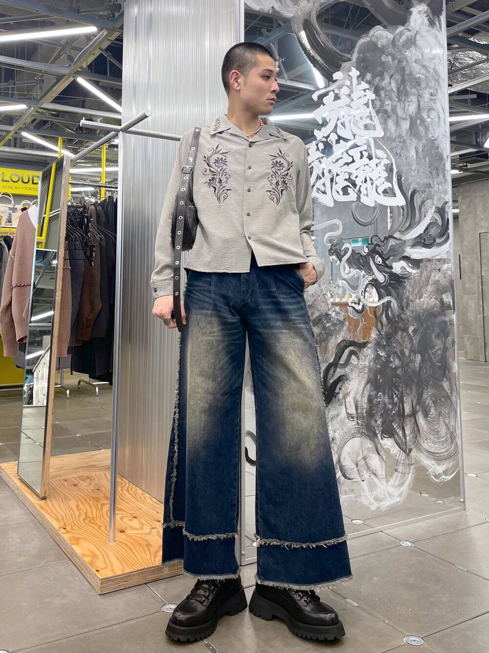 ブラック系のショルダーバッグ、ブラック系のドレスシューズ、ブルー系のデニムパンツを着用したメンズの冬コーディネートの1枚目の写真