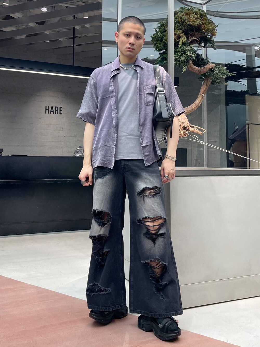 ブラック系のショルダーバッグ、ブラック系のサンダル、ブラック系のデニムパンツを着用したメンズの春コーディネートの1枚目の写真