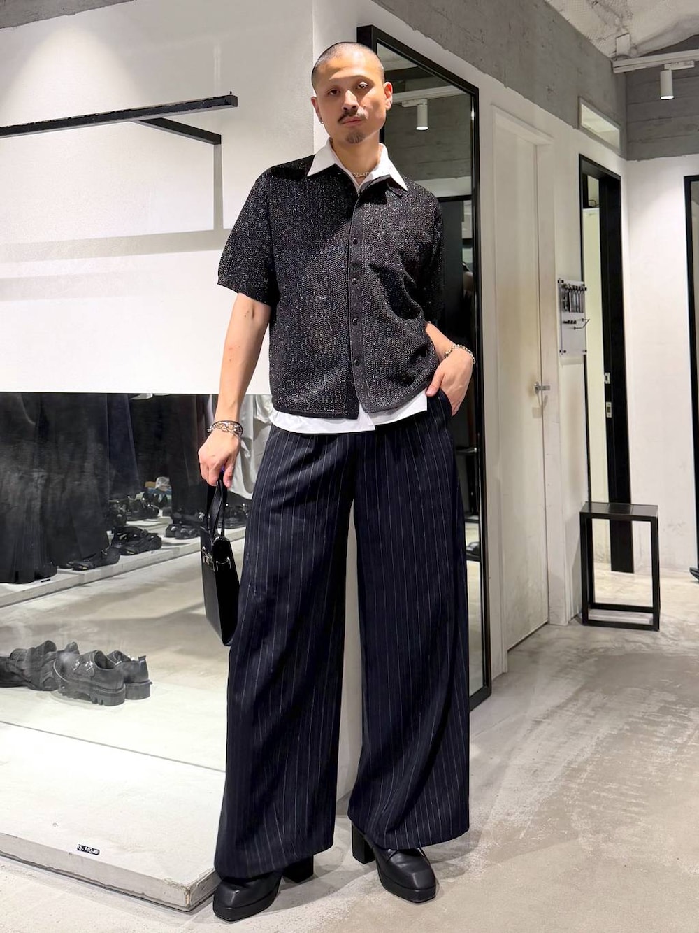 ブラック系のサンダル、ブルー系のスラックス、シルバー系のニット/セーターを着用したメンズの夏コーディネートの1枚目の写真