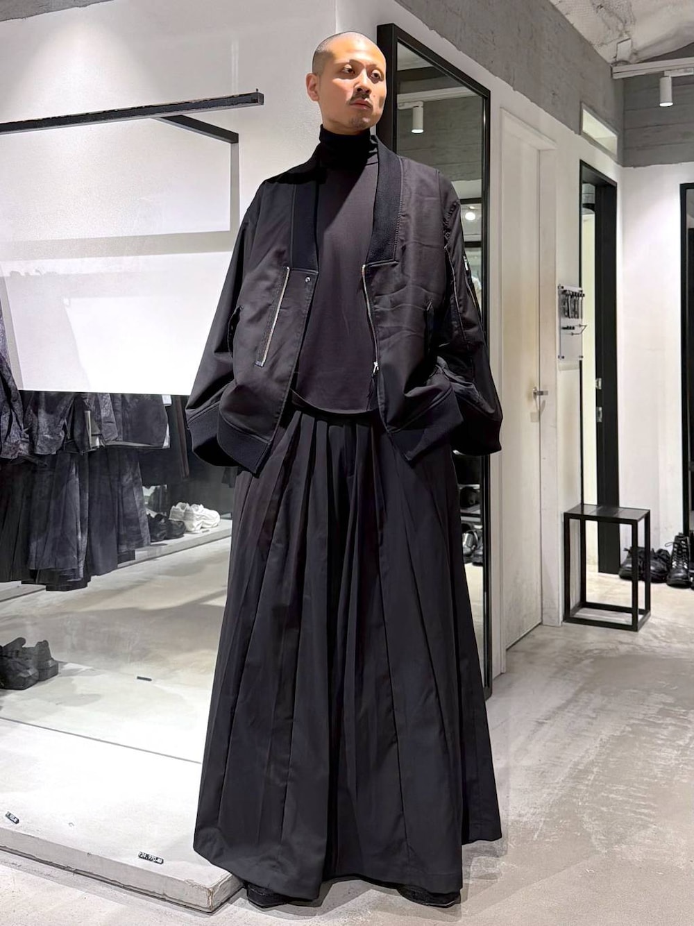 ブラック系のブルゾン、ブラック系のTシャツ/カットソー、ブラック系のブーツを着用したメンズの秋コーディネートの1枚目の写真