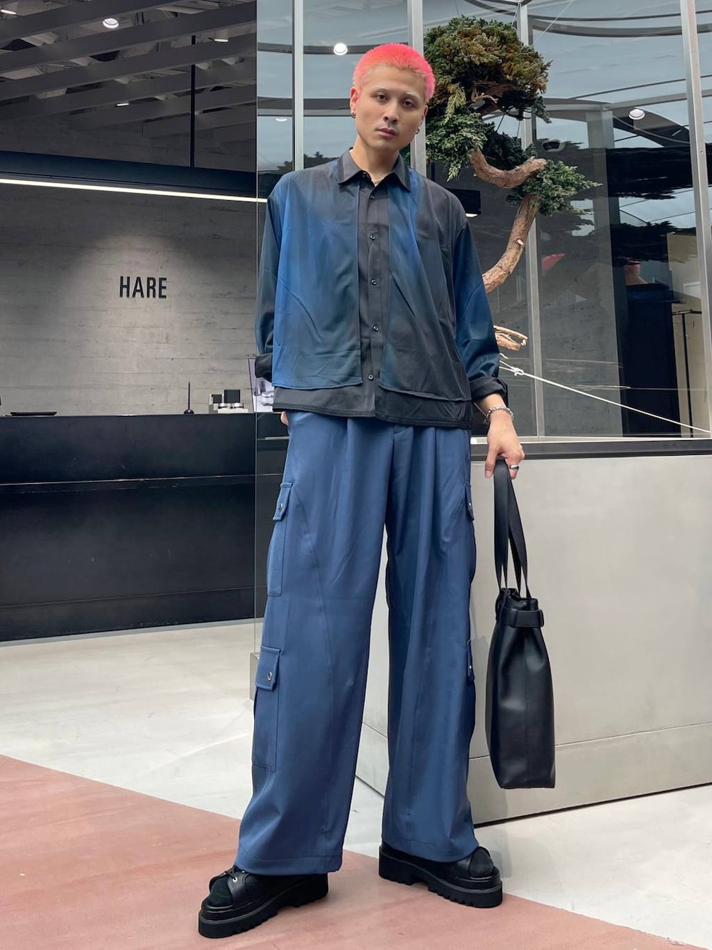 ブラック系のサンダル、ブルー系のカーゴパンツ、ブラック系のトートバッグを着用したメンズの夏コーディネートの1枚目の写真