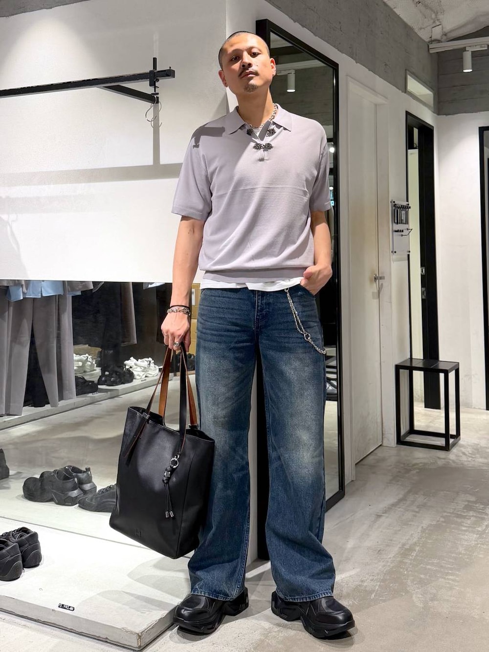 ブラック系のスニーカー、ブラック系のトートバッグ、ブルー系のデニムパンツを着用したメンズの夏コーディネートの1枚目の写真