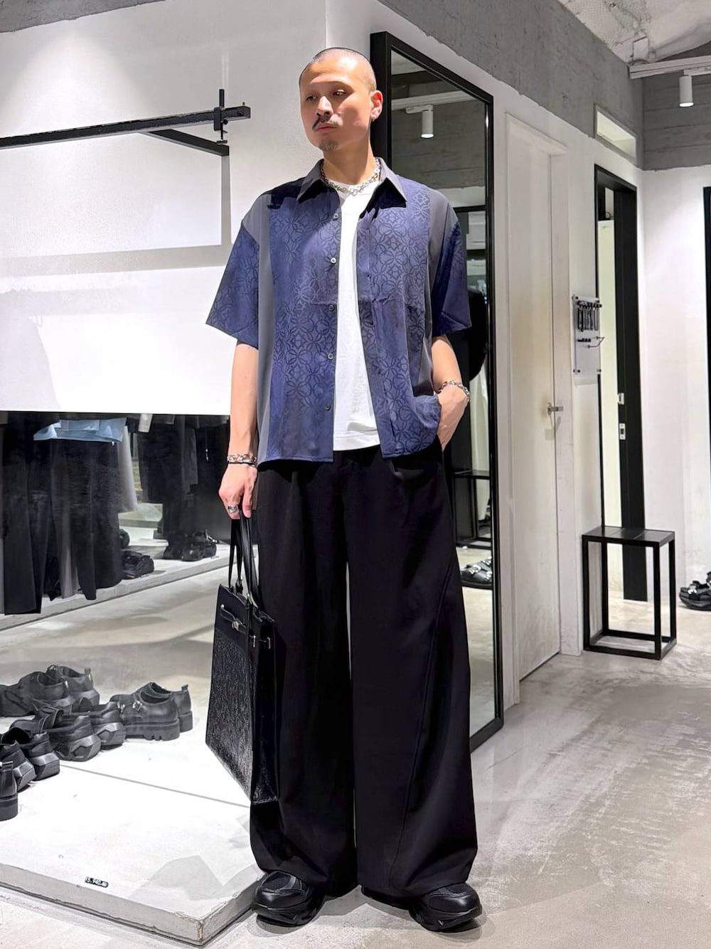 ブラック系のスニーカー、ホワイト系のTシャツ/カットソー、ブラック系のスラックスを着用したメンズの夏コーディネートの1枚目の写真
