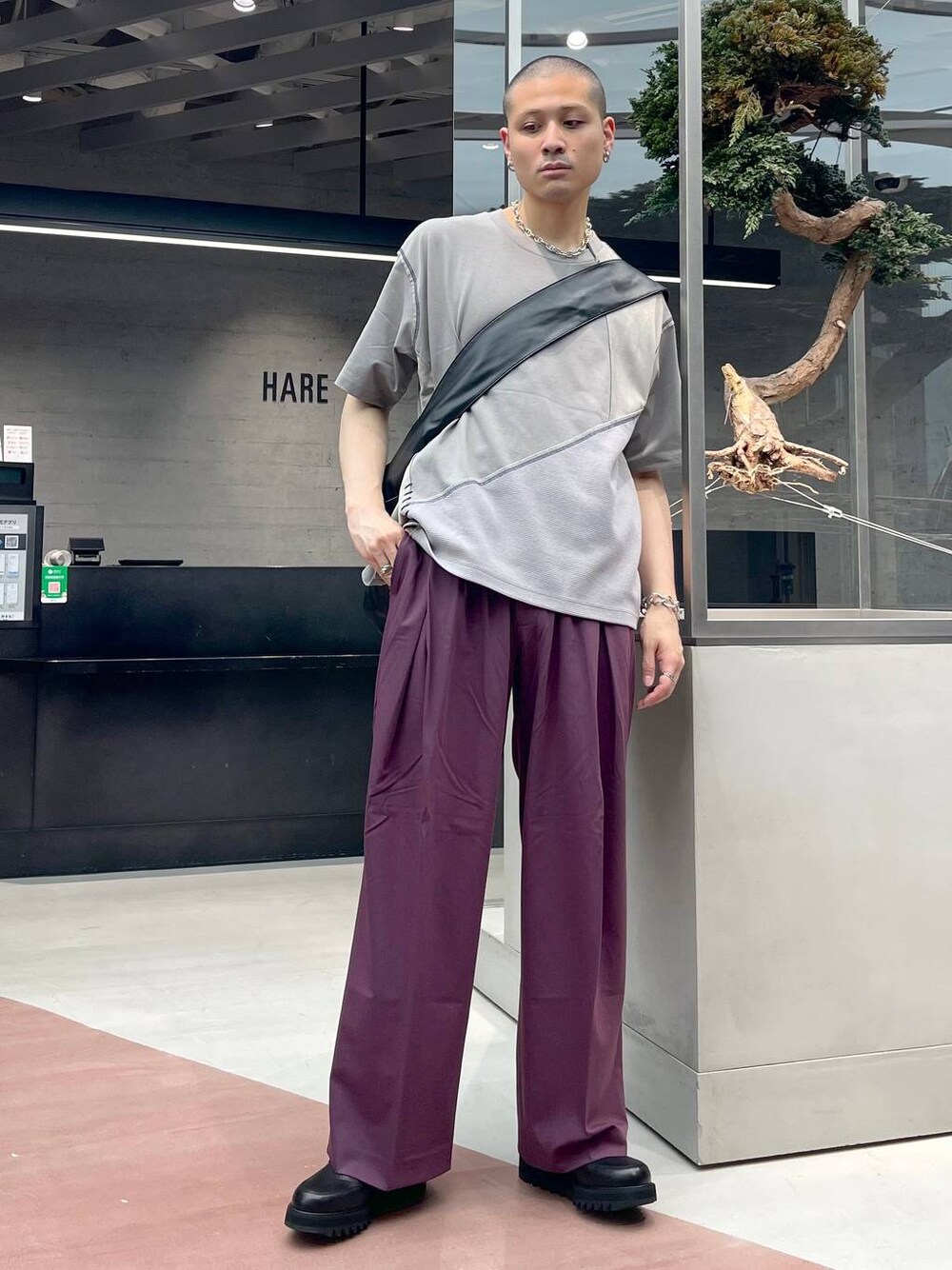 ブラック系のショルダーバッグ、レッド系のスラックス、グレー系のTシャツ/カットソーを着用したメンズの夏コーディネートの1枚目の写真