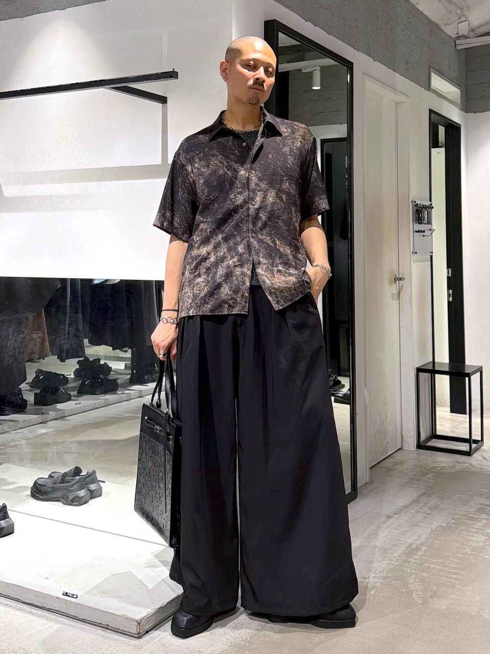 ブラック系のサンダル、ブラック系のトートバッグ、グレー系のブレスレットを着用したメンズの夏コーディネートの1枚目の写真