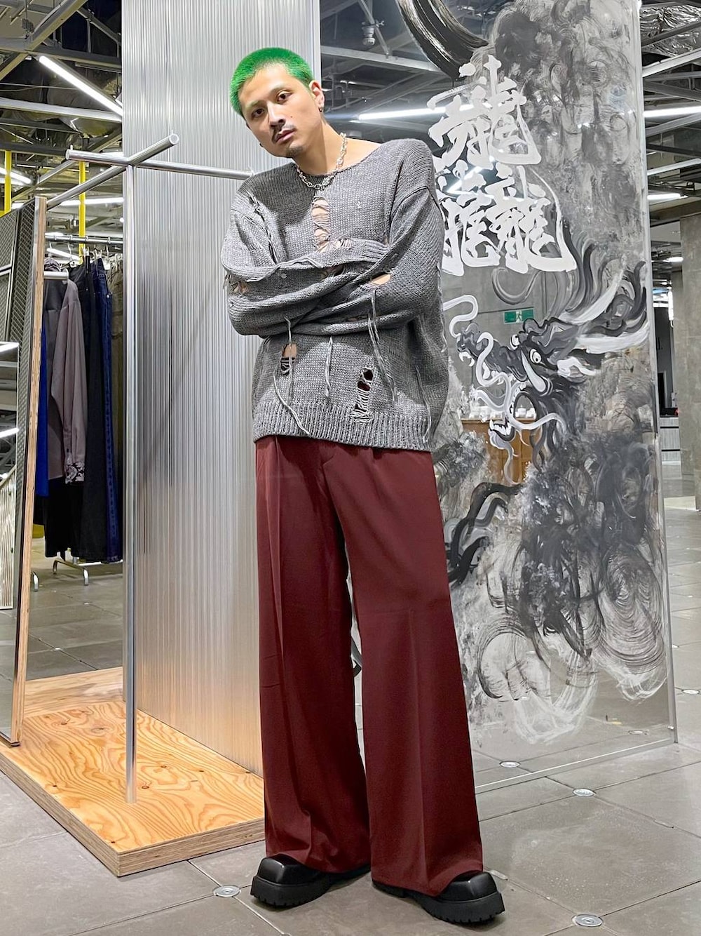 ブラック系のドレスシューズ、レッド系のスラックス、グレー系のニット/セーターを着用したメンズの秋コーディネートの1枚目の写真