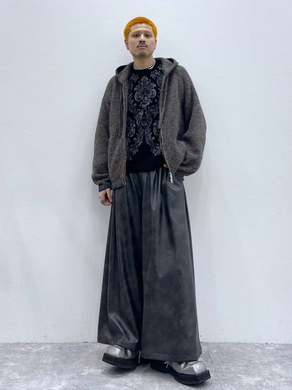 ブラック系のその他パンツ、ブラック系のニット/セーター、ブラウン系のニット/セーターを着用したメンズの秋コーディネートの1枚目の写真