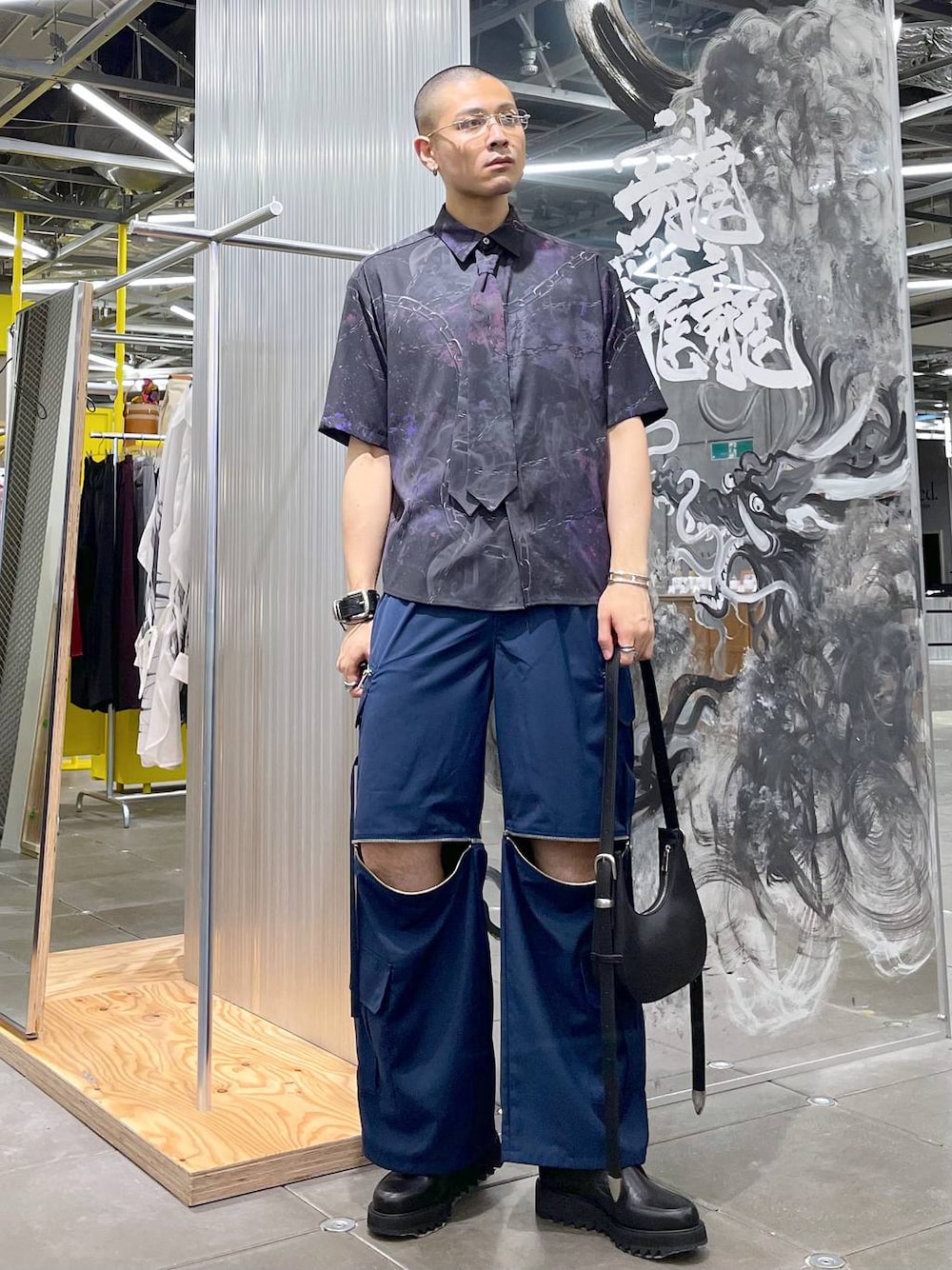 ブルー系のカーゴパンツ、ブラック系のドレスシューズ、ブラック系のショルダーバッグを着用したメンズの夏コーディネートの1枚目の写真