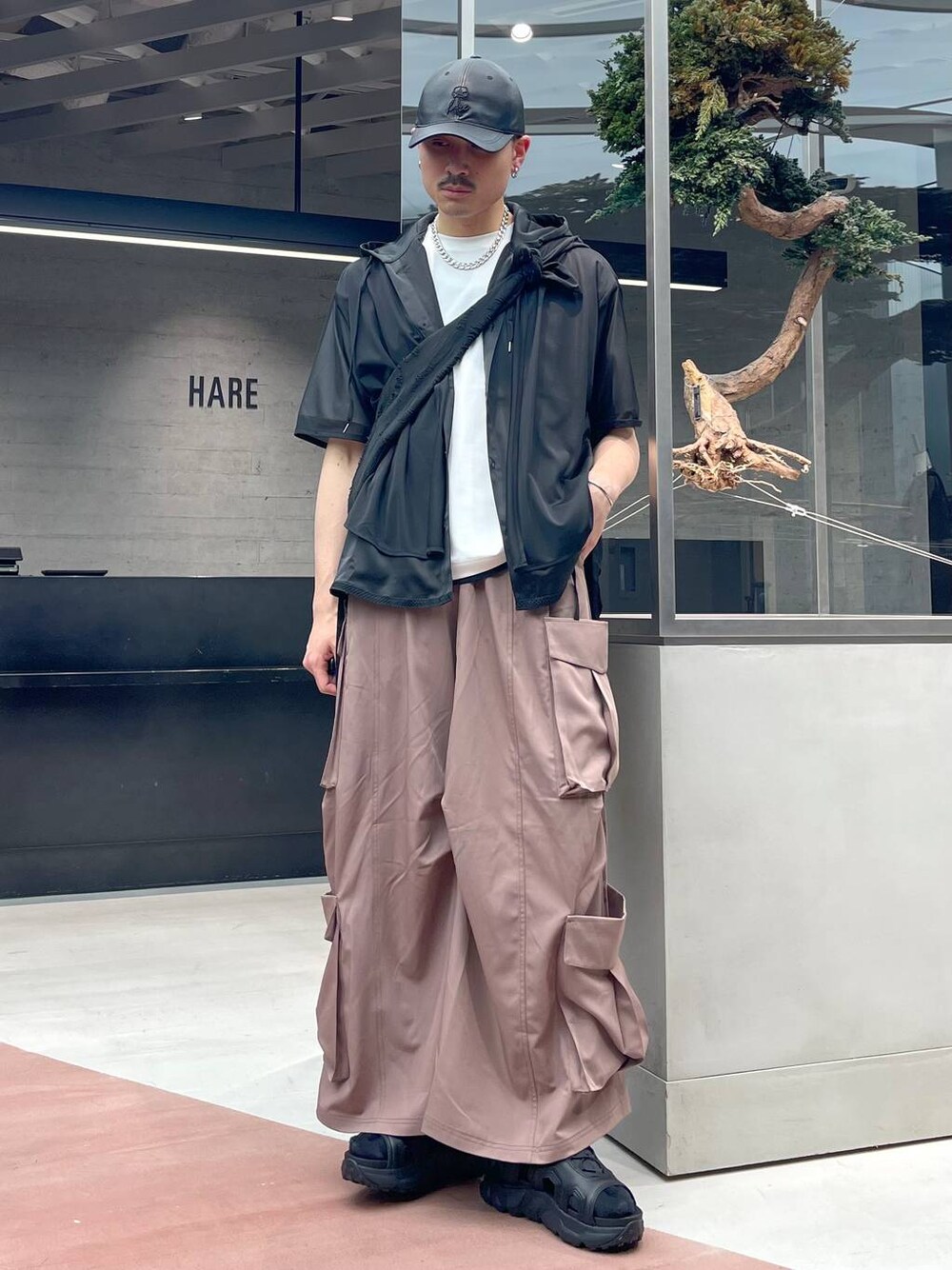 ブラック系のショルダーバッグ、ピンク系のカーゴパンツ、ブラック系のサンダルを着用したメンズの春コーディネートの1枚目の写真