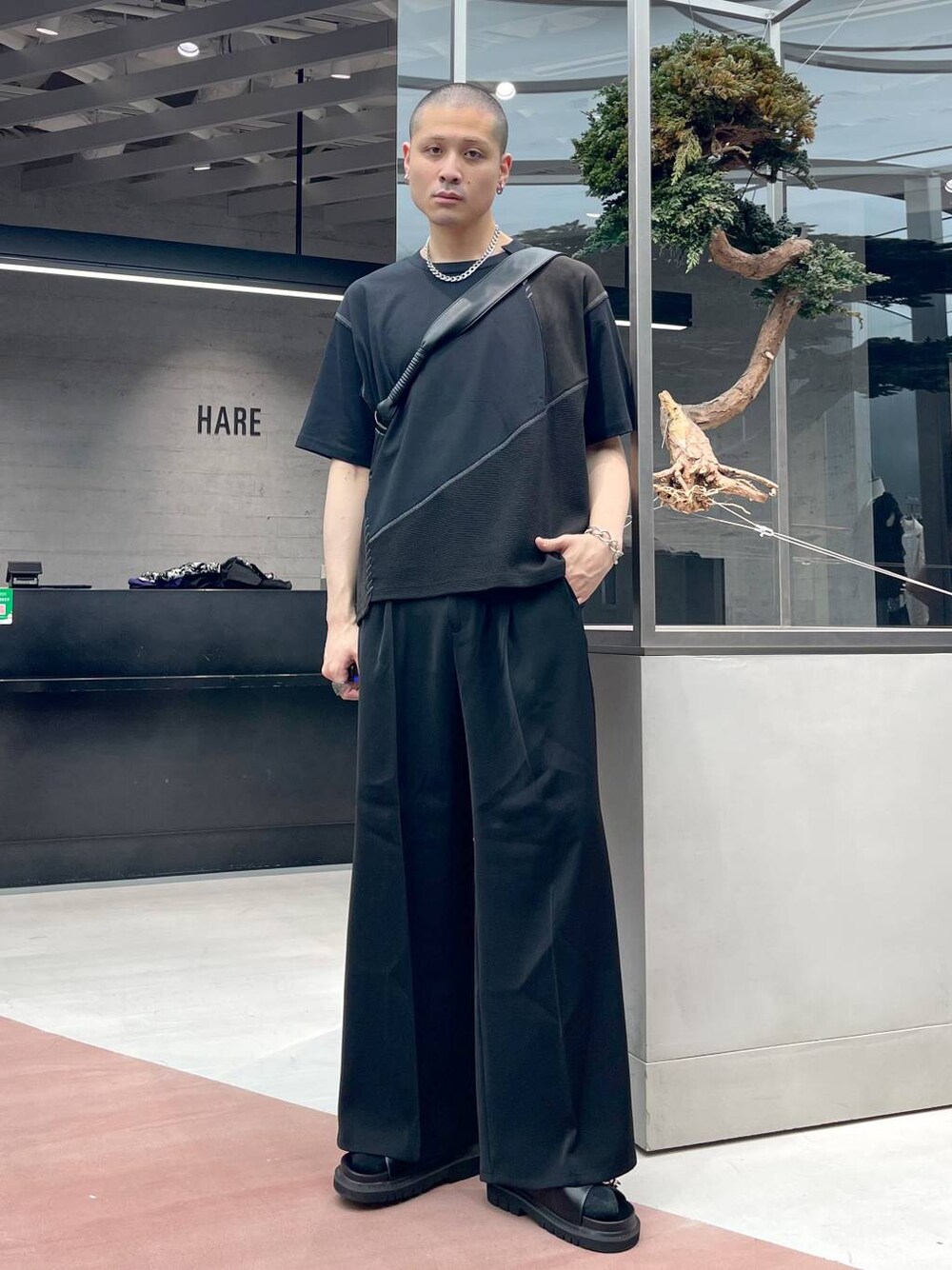 ブラック系のスラックス、ブラック系のサンダル、ブラック系のTシャツ/カットソーを着用したメンズの夏コーディネートの1枚目の写真