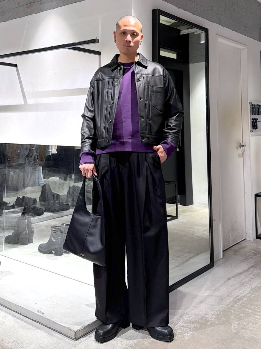 ブラック系のトートバッグ、ブラック系のブーツ、パープル系のスウェットを着用したメンズの冬コーディネートの1枚目の写真