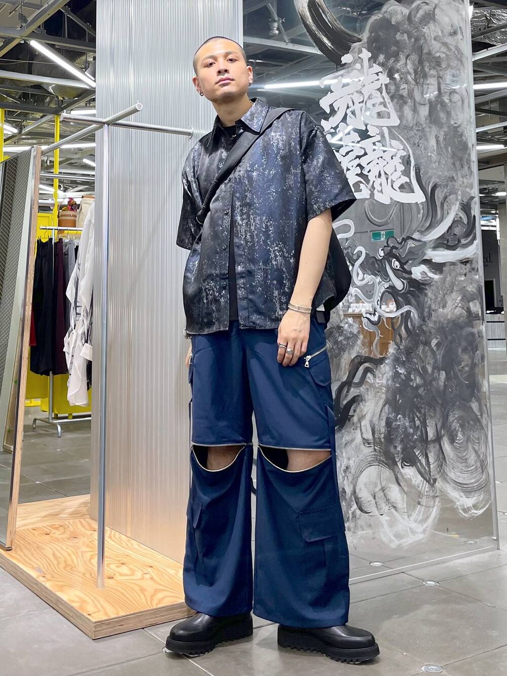 ブルー系のカーゴパンツ、ブラック系のドレスシューズ、ブラック系のショルダーバッグを着用したメンズの夏コーディネートの1枚目の写真
