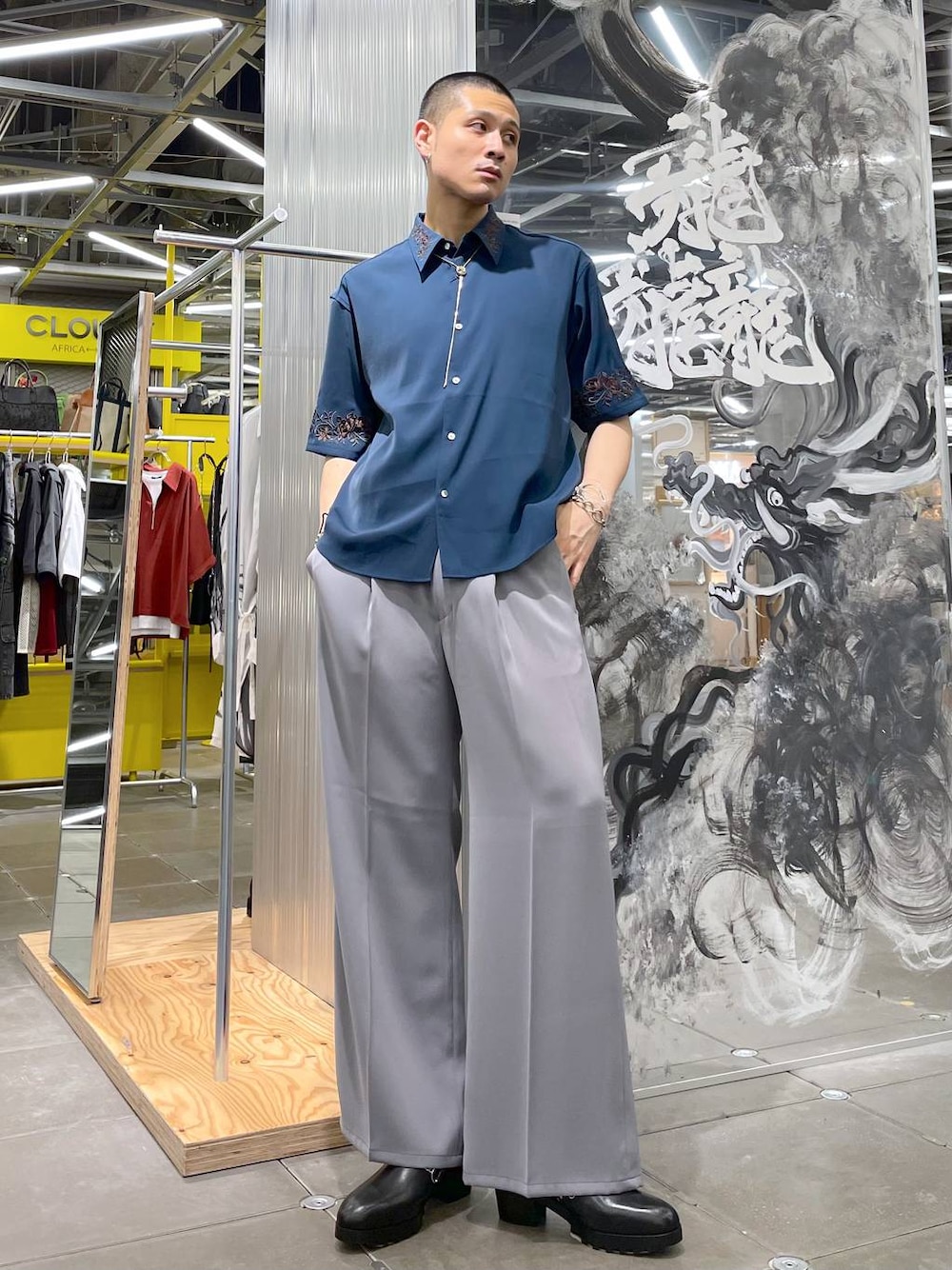 グレー系のスラックス、ブルー系のシャツ/ブラウス、ブラック系のドレスシューズを着用したメンズの夏コーディネートの1枚目の写真