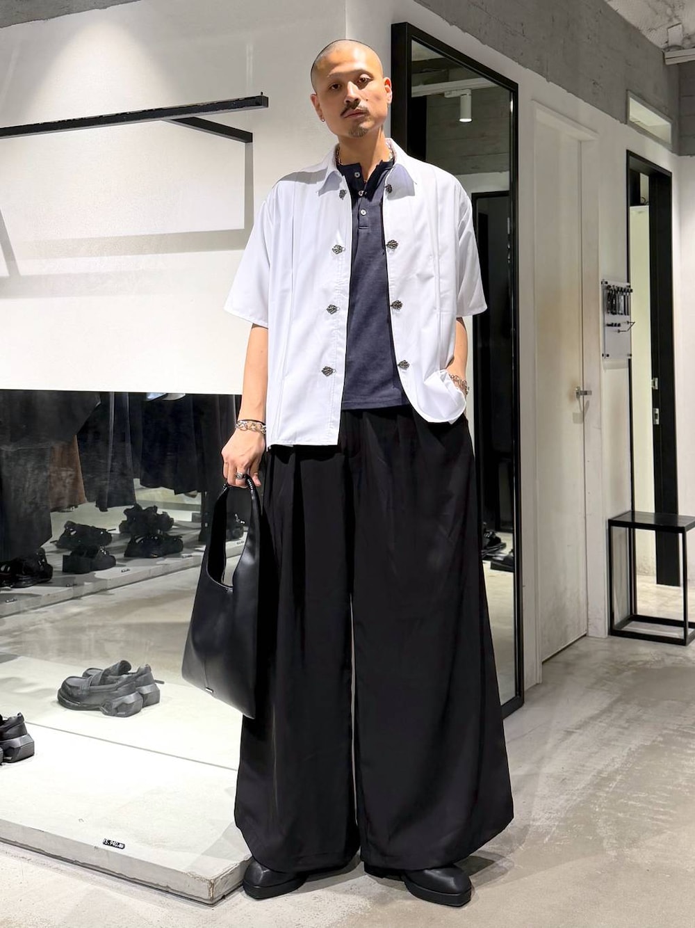 ブラック系のトートバッグ、ブラック系のサンダル、ブルー系のTシャツ/カットソーを着用したメンズの夏コーディネートの1枚目の写真