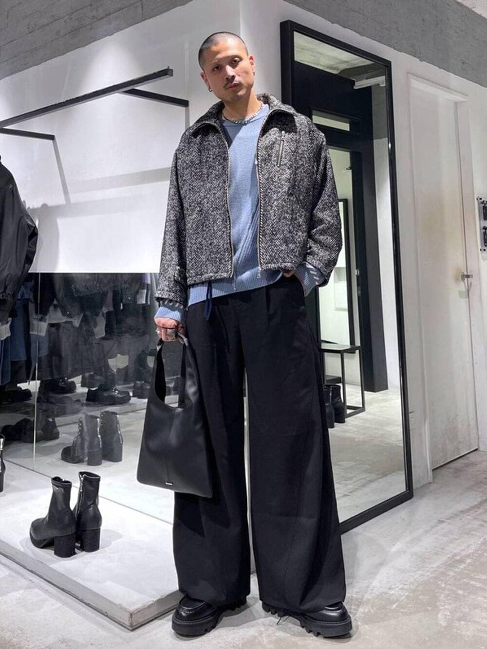 ブラック系のトートバッグ、グレー系のブルゾン、ブラック系のスラックスを着用したメンズの冬コーディネートの1枚目の写真