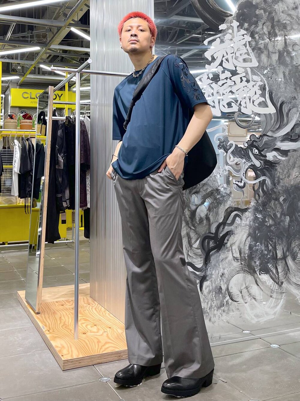 ブラック系のドレスシューズ、ブラック系のショルダーバッグ、グレー系のスラックスを着用したメンズの夏コーディネートの1枚目の写真