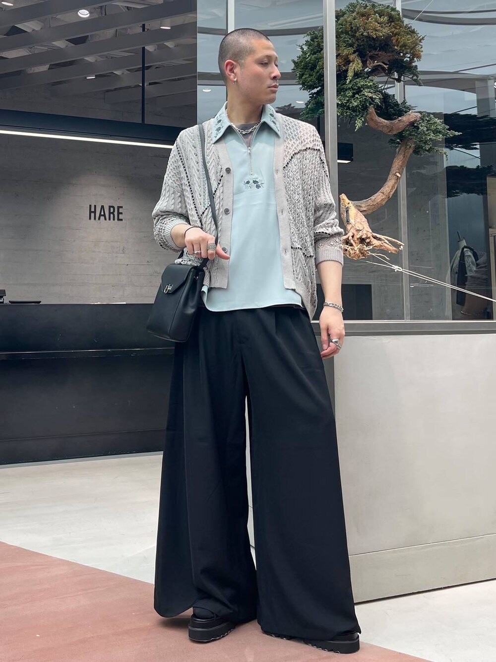 ブラック系のサンダル、グレー系のTシャツ/カットソー、ブラック系のショルダーバッグを着用したメンズの春コーディネートの1枚目の写真