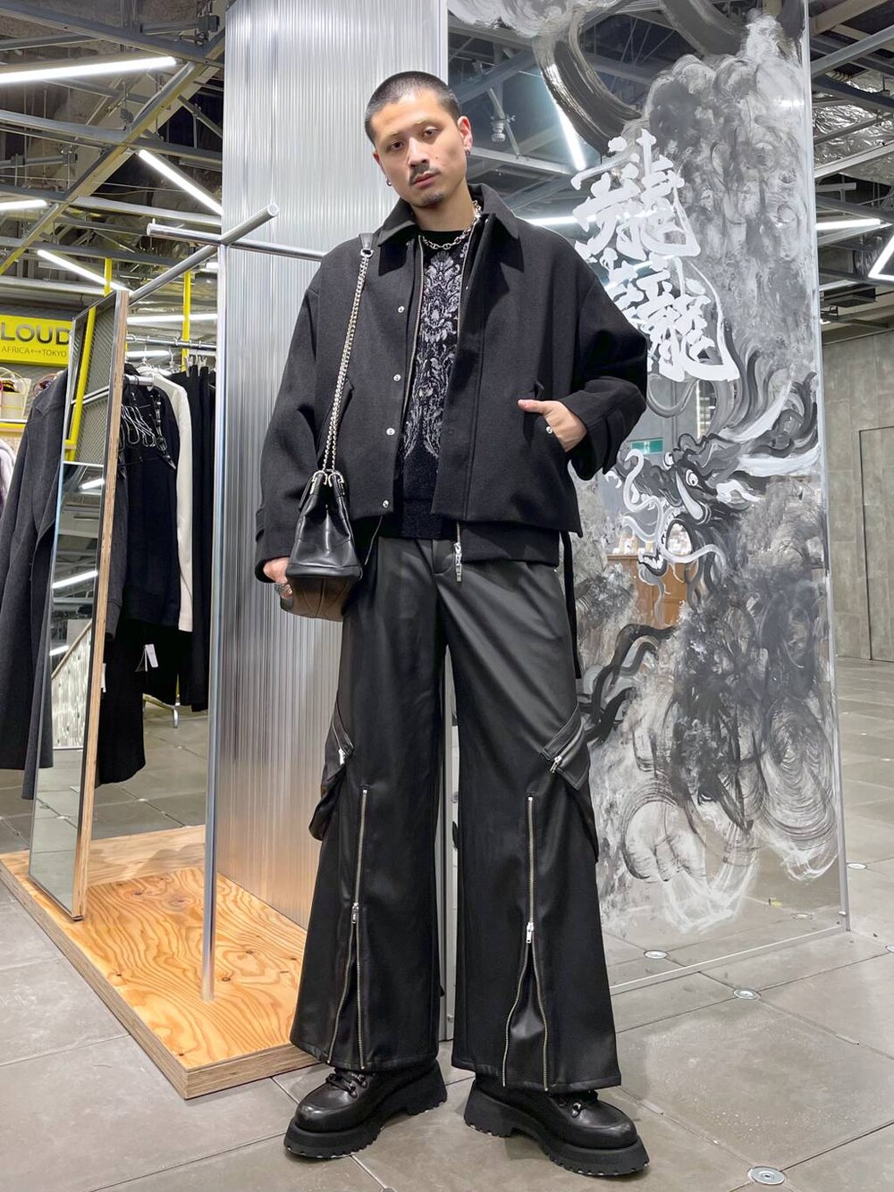 ブラック系のブルゾン、ブラック系のニット/セーター、ブラック系のカーゴパンツを着用したメンズの冬コーディネートの1枚目の写真