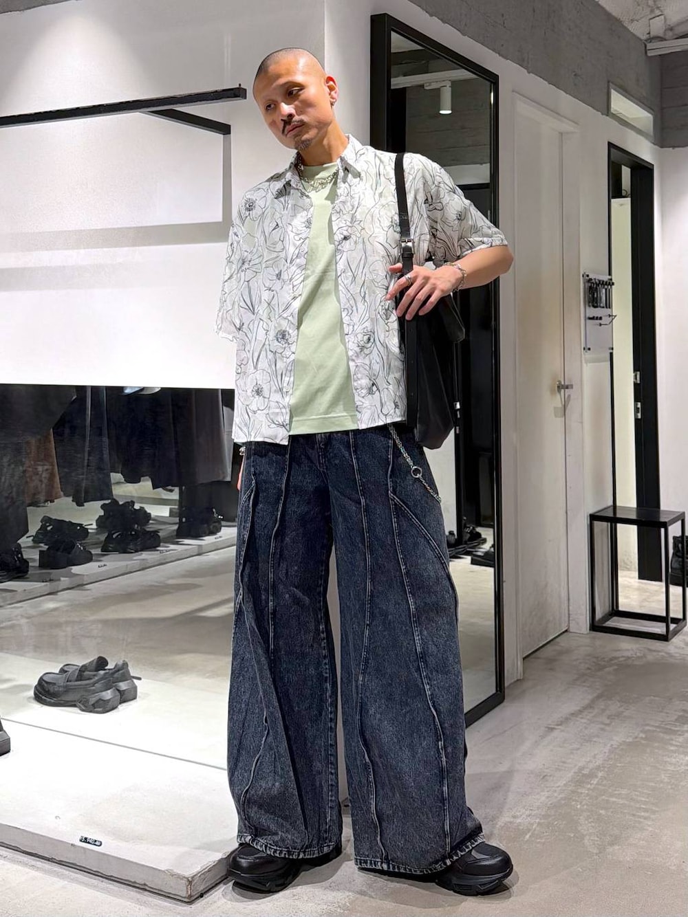 ブラック系のスニーカー、ブルー系のデニムパンツ、グリーン系のTシャツ/カットソーを着用したメンズの夏コーディネートの1枚目の写真