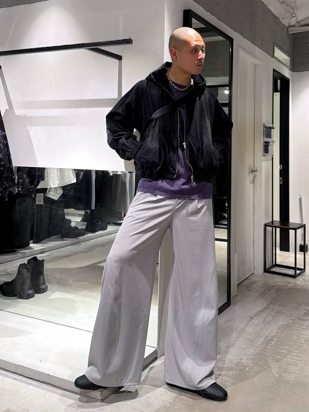 ブラック系のブルゾン、グレー系のスラックス、ブラック系のショルダーバッグを着用したメンズの春コーディネートの1枚目の写真