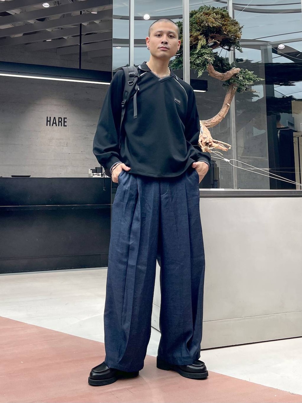 ブルー系のスラックス、ブラック系のローファー、ブラック系のバックパック/リュックを着用したメンズの秋コーディネートの1枚目の写真