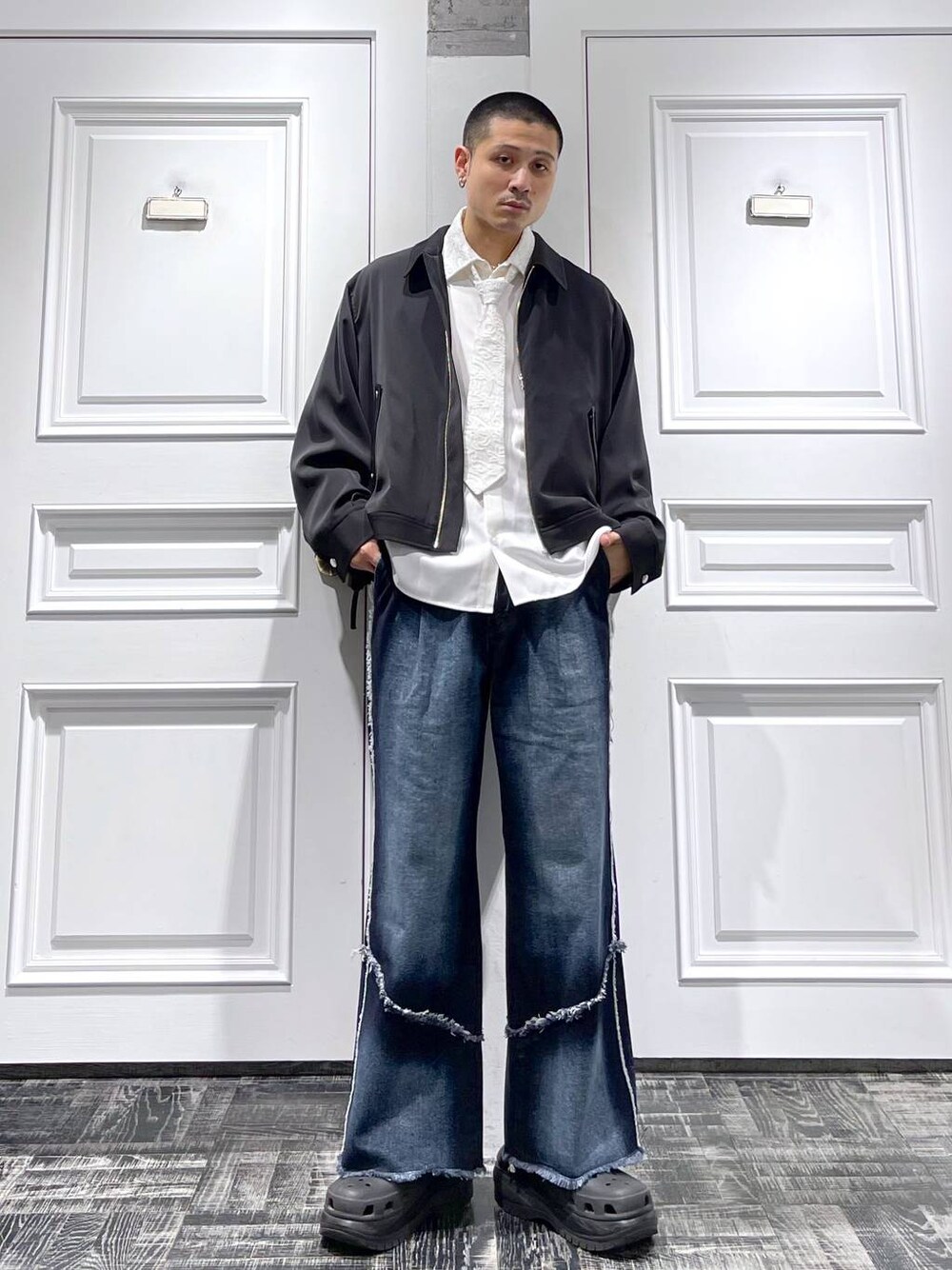 ブラック系のブルゾン、ホワイト系のシャツ/ブラウス、ブルー系のデニムパンツを着用したメンズの春コーディネートの1枚目の写真