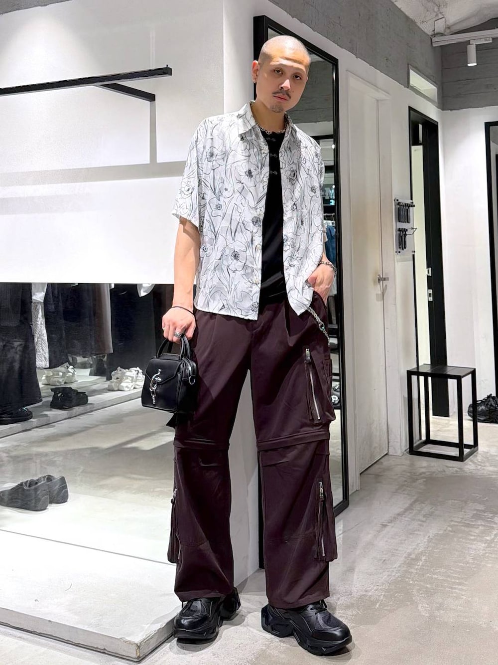 ブラック系のスニーカー、ブラウン系のカーゴパンツ、ブラック系のショルダーバッグを着用したメンズの夏コーディネートの1枚目の写真