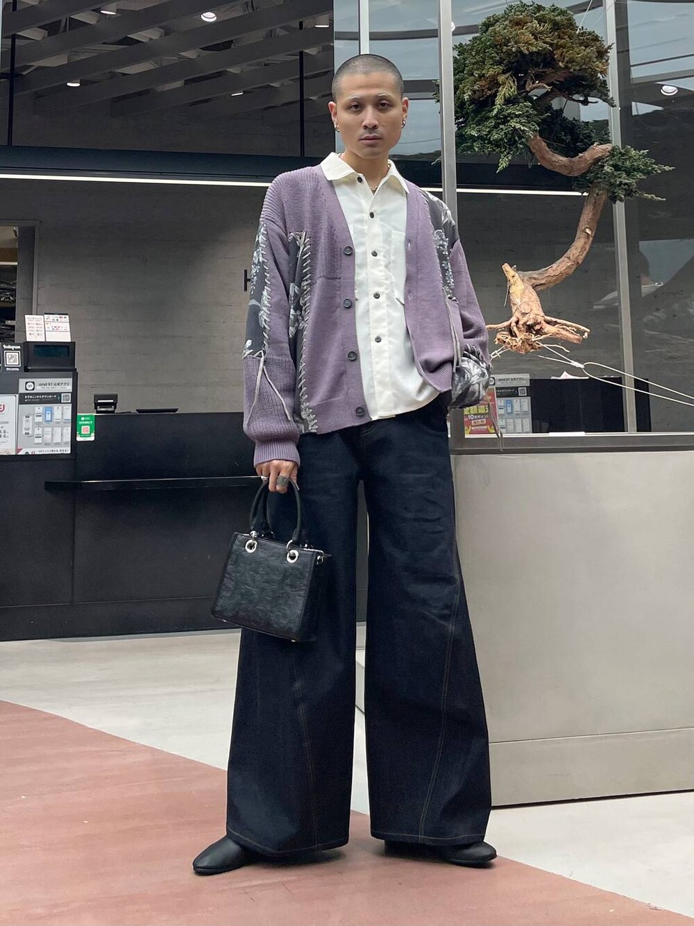 ブルー系のデニムパンツ、ブラック系のショルダーバッグ、ブラック系のバレエシューズを着用したメンズの秋コーディネートの1枚目の写真