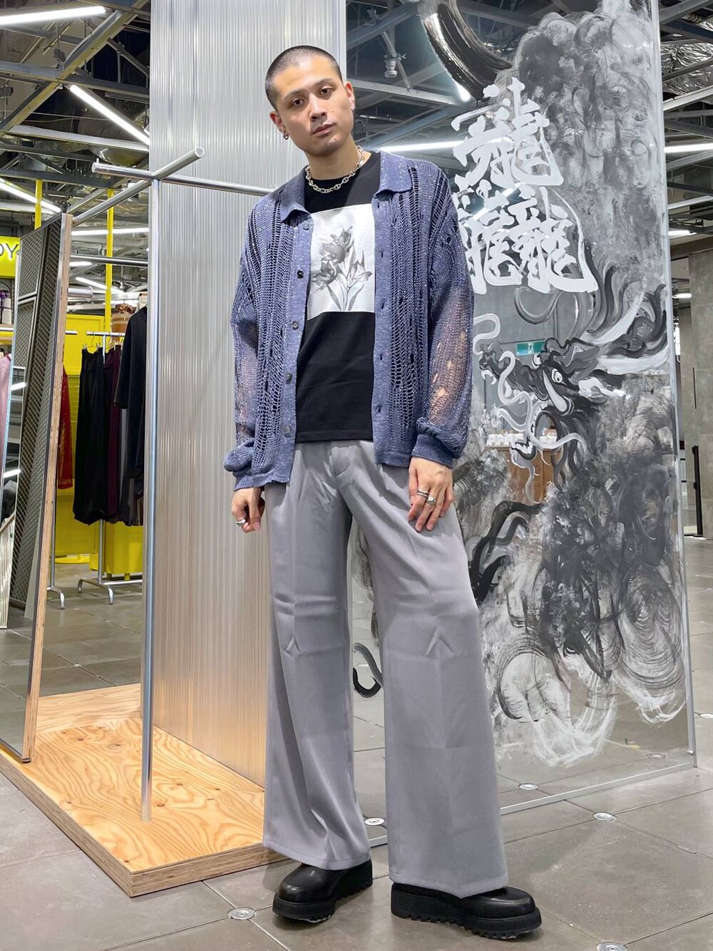 グレー系のスラックス、ブラック系のドレスシューズ、ブラック系のTシャツ/カットソーを着用したメンズの夏コーディネートの1枚目の写真