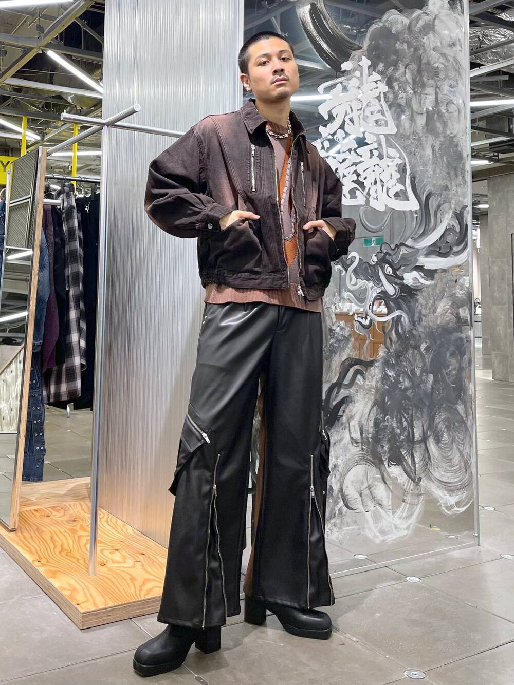 ブラック系のブーツ、ブラウン系のニット/セーター、レッド系のデニムジャケットを着用したメンズの秋コーディネートの1枚目の写真