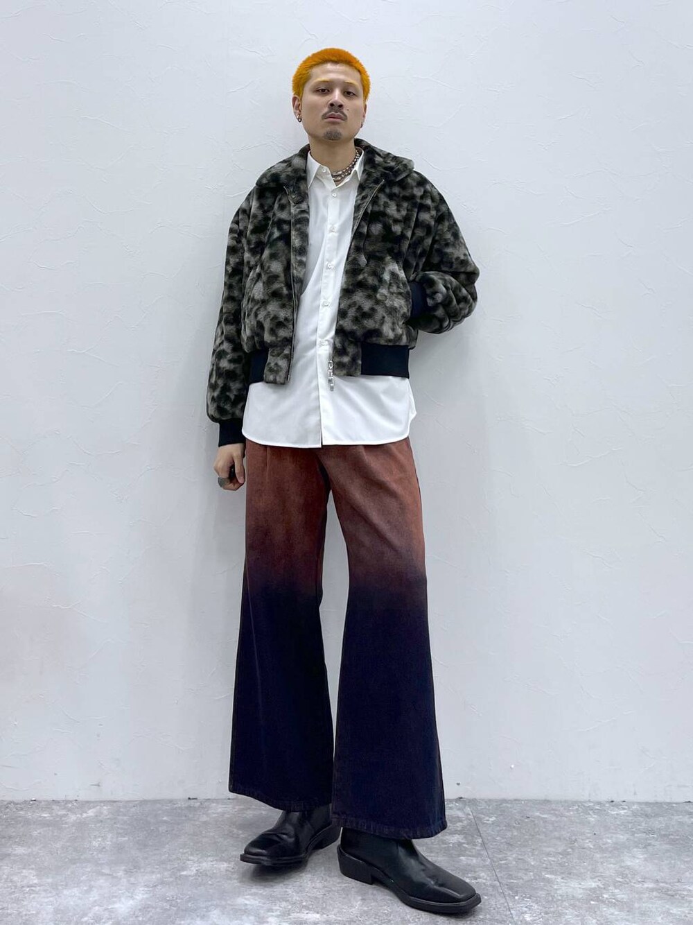 オレンジ系のデニムパンツ、ホワイト系のシャツ/ブラウス、ブラック系のブーツを着用したメンズの秋コーディネートの1枚目の写真