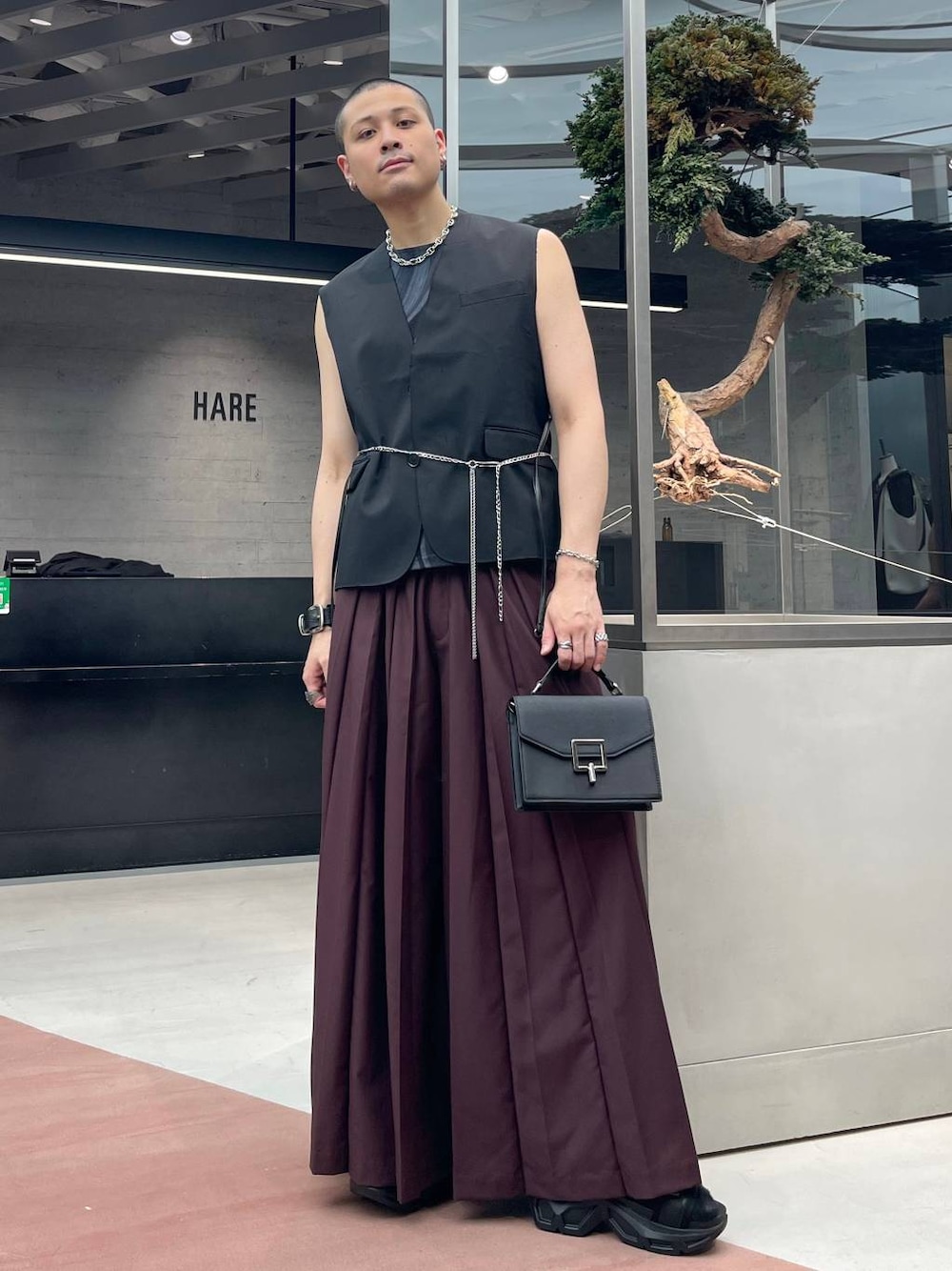 レッド系のその他パンツ、ブラック系のサンダル、ブラック系のショルダーバッグを着用したメンズの夏コーディネートの1枚目の写真