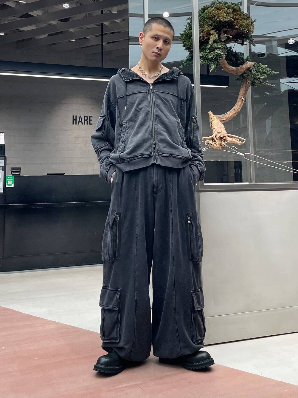 ブラック系のスウェットパンツ、ブラック系のパーカー、ブラック系のブーツを着用したメンズの秋コーディネートの1枚目の写真