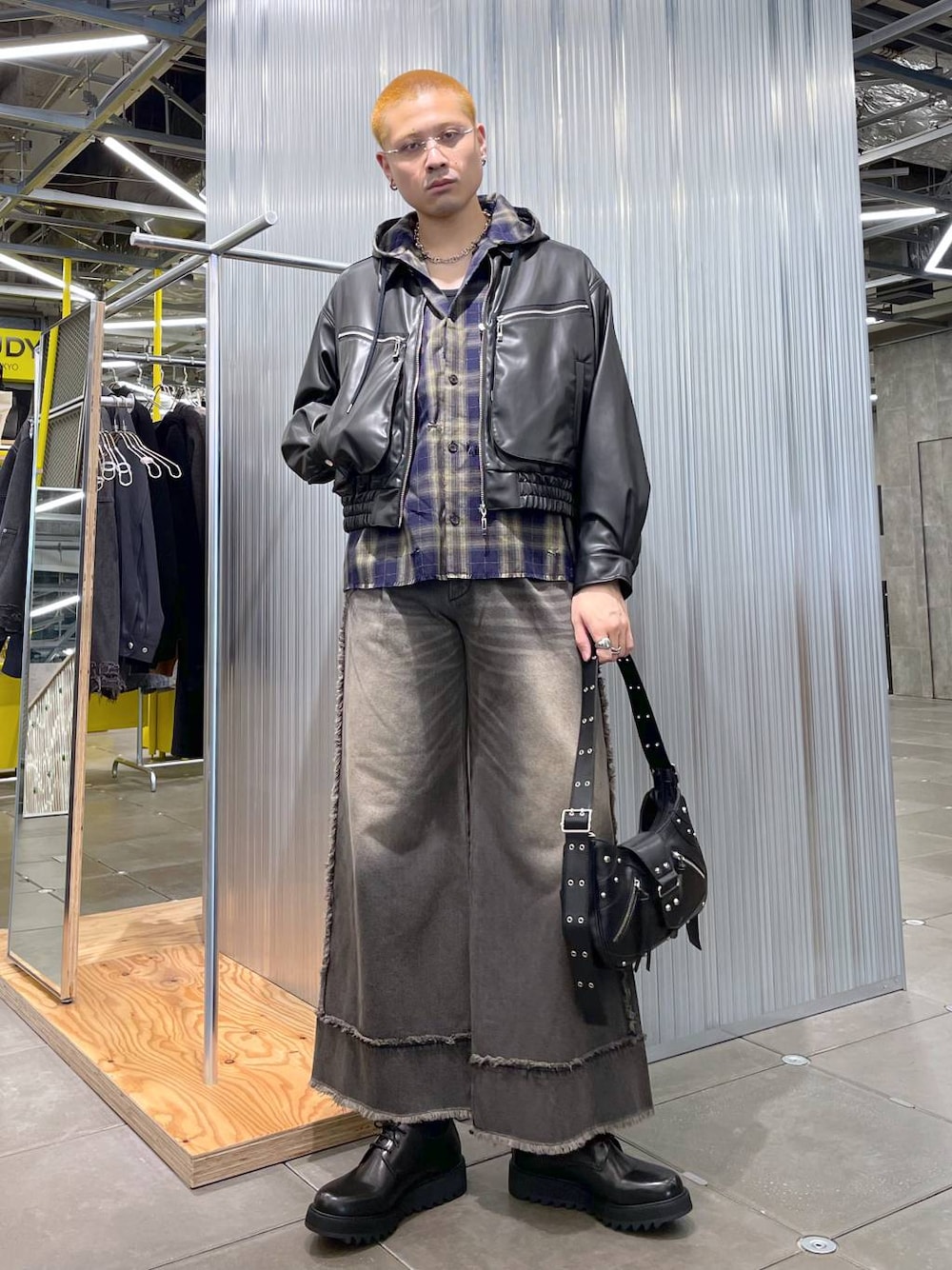 ブラウン系のデニムパンツ、ブラック系のショルダーバッグ、ブラック系のドレスシューズを着用したメンズの冬コーディネートの1枚目の写真