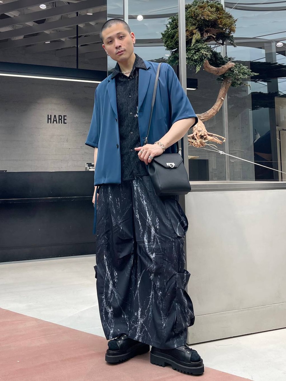 ブラック系のサンダル、ブラック系のカーゴパンツ、ブルー系のテーラードジャケットを着用したメンズの夏コーディネートの1枚目の写真