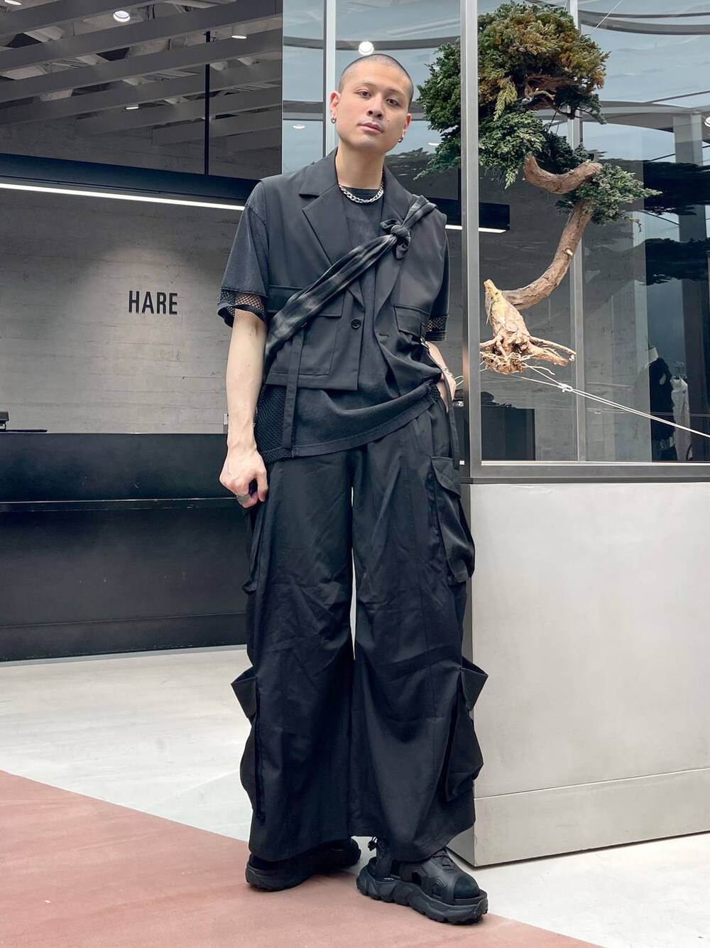 ブラック系のショルダーバッグ、ブラック系のカーゴパンツ、ブラック系のサンダルを着用したメンズの夏コーディネートの1枚目の写真