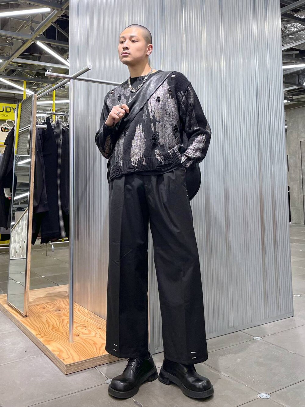 ブラック系のドレスシューズ、ブラック系のニット/セーター、ブラック系のショルダーバッグを着用したメンズの冬コーディネートの1枚目の写真