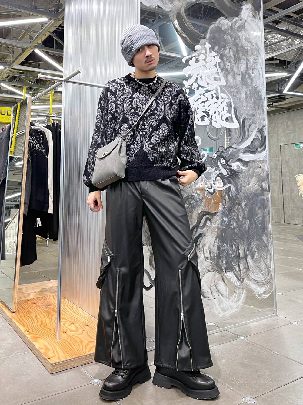 ブラック系のニット/セーター、グレー系のショルダーバッグ、ブラック系のカーゴパンツを着用したメンズの冬コーディネートの1枚目の写真