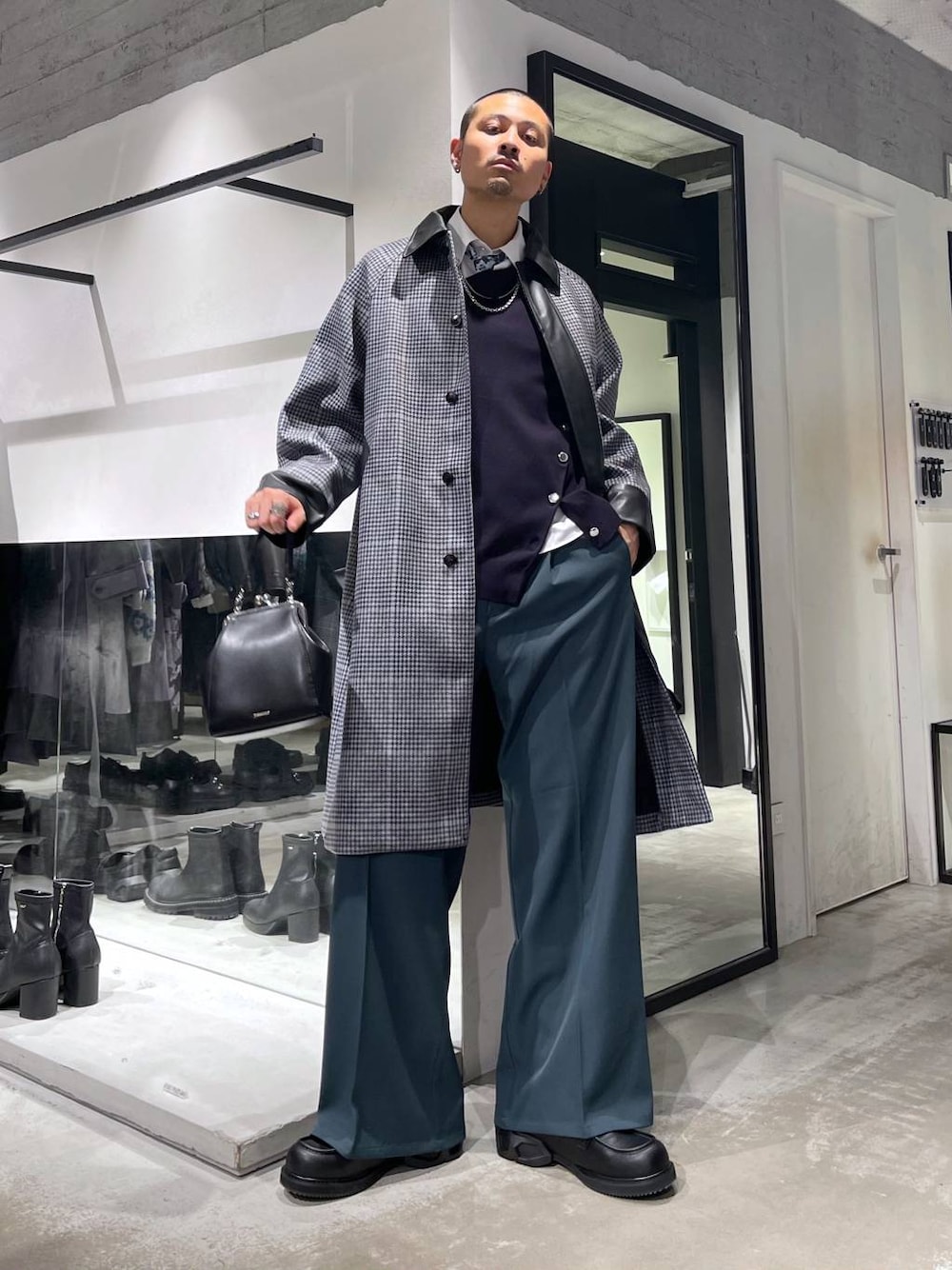 ホワイト系のネクタイ、ベージュ系のステンカラーコート、ブラック系のショルダーバッグを着用したメンズの秋コーディネートの1枚目の写真